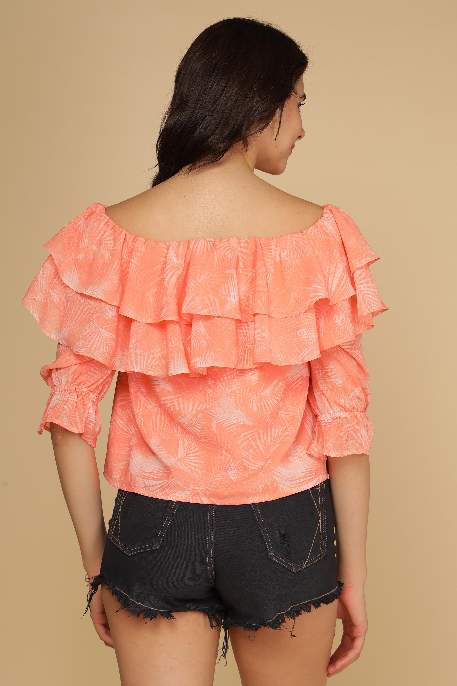 Peach printed top with frills, perfect for summer fashion.