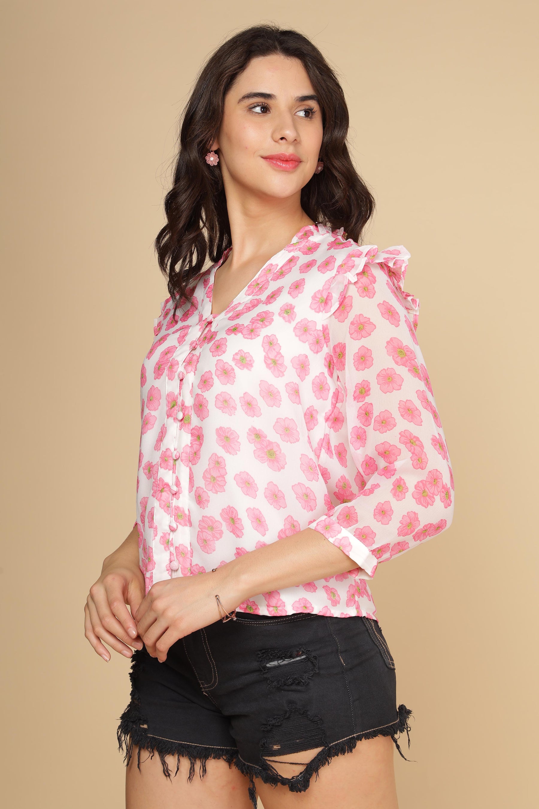Pink ruffle floral top paired with black denim shorts.