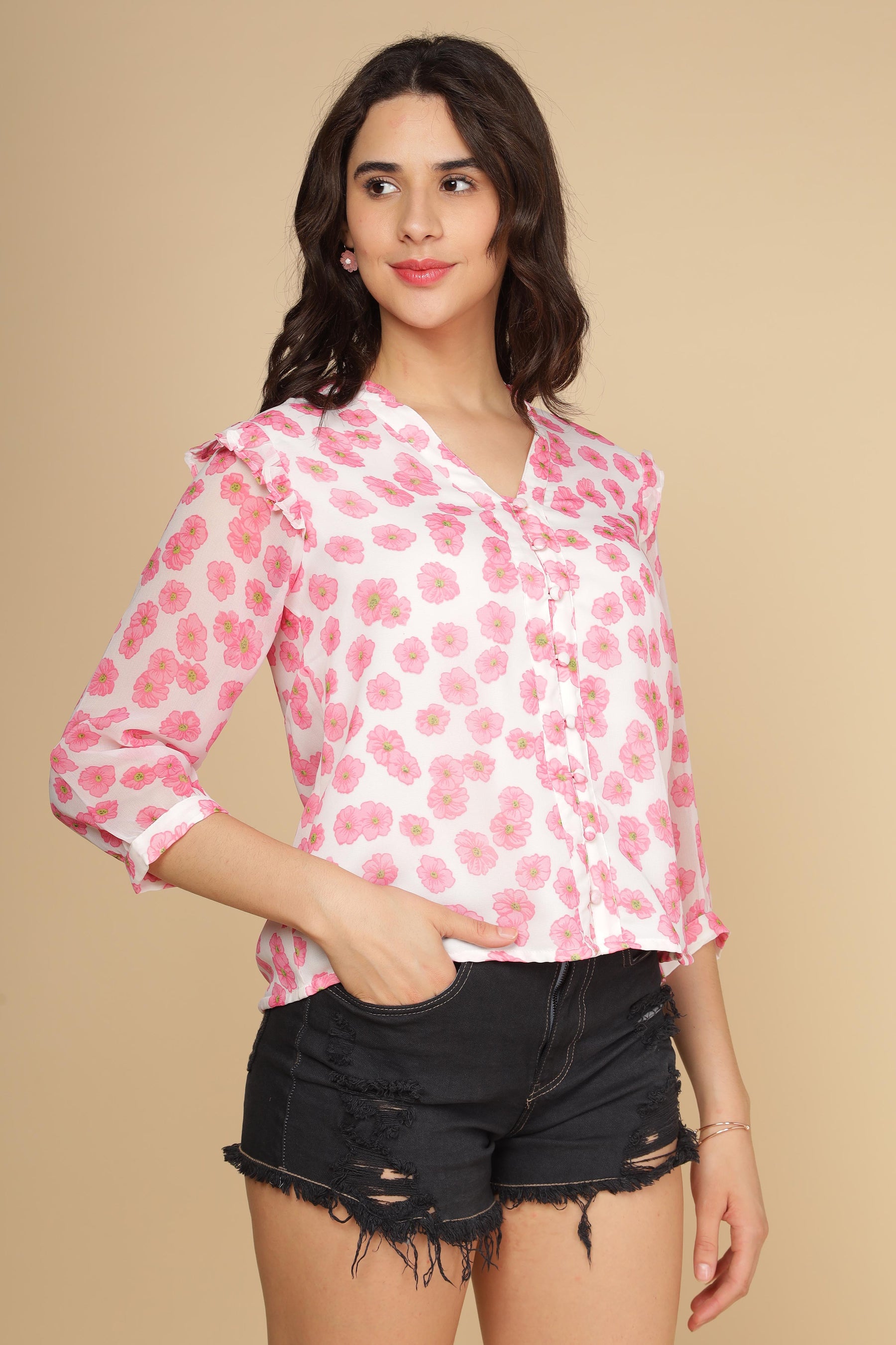 Pink ruffle floral top paired with distressed black shorts.