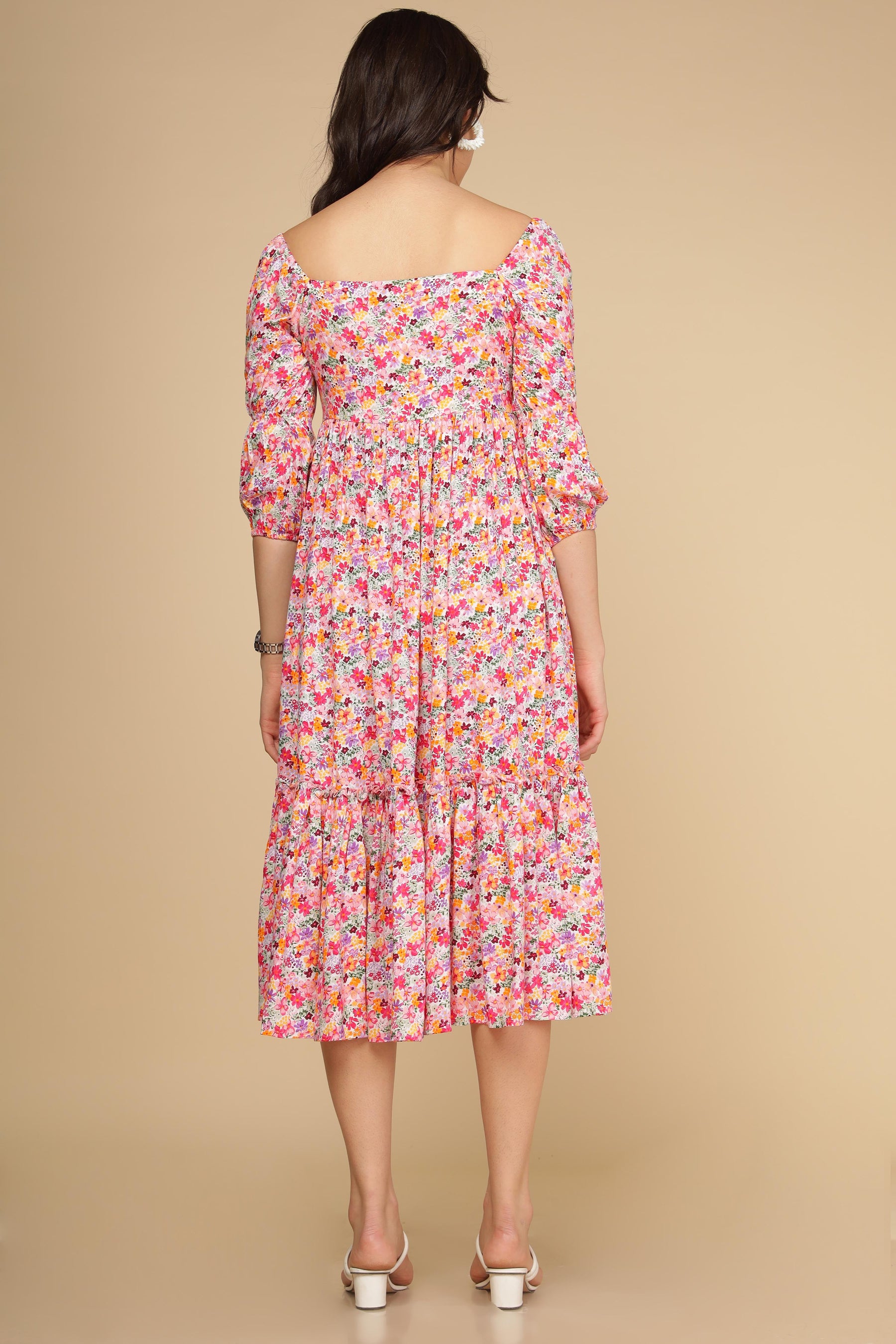Back view of a woman wearing a white floral cotton maxi dress.