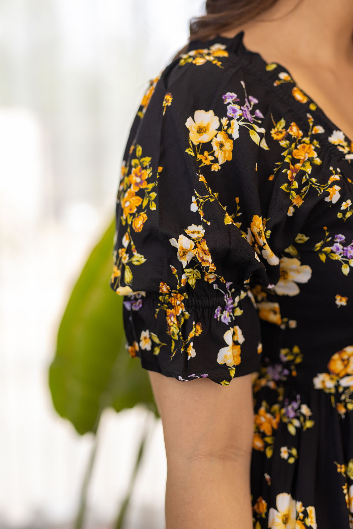 Black floral nursing maxi dress with puffed sleeves and vibrant flowers.