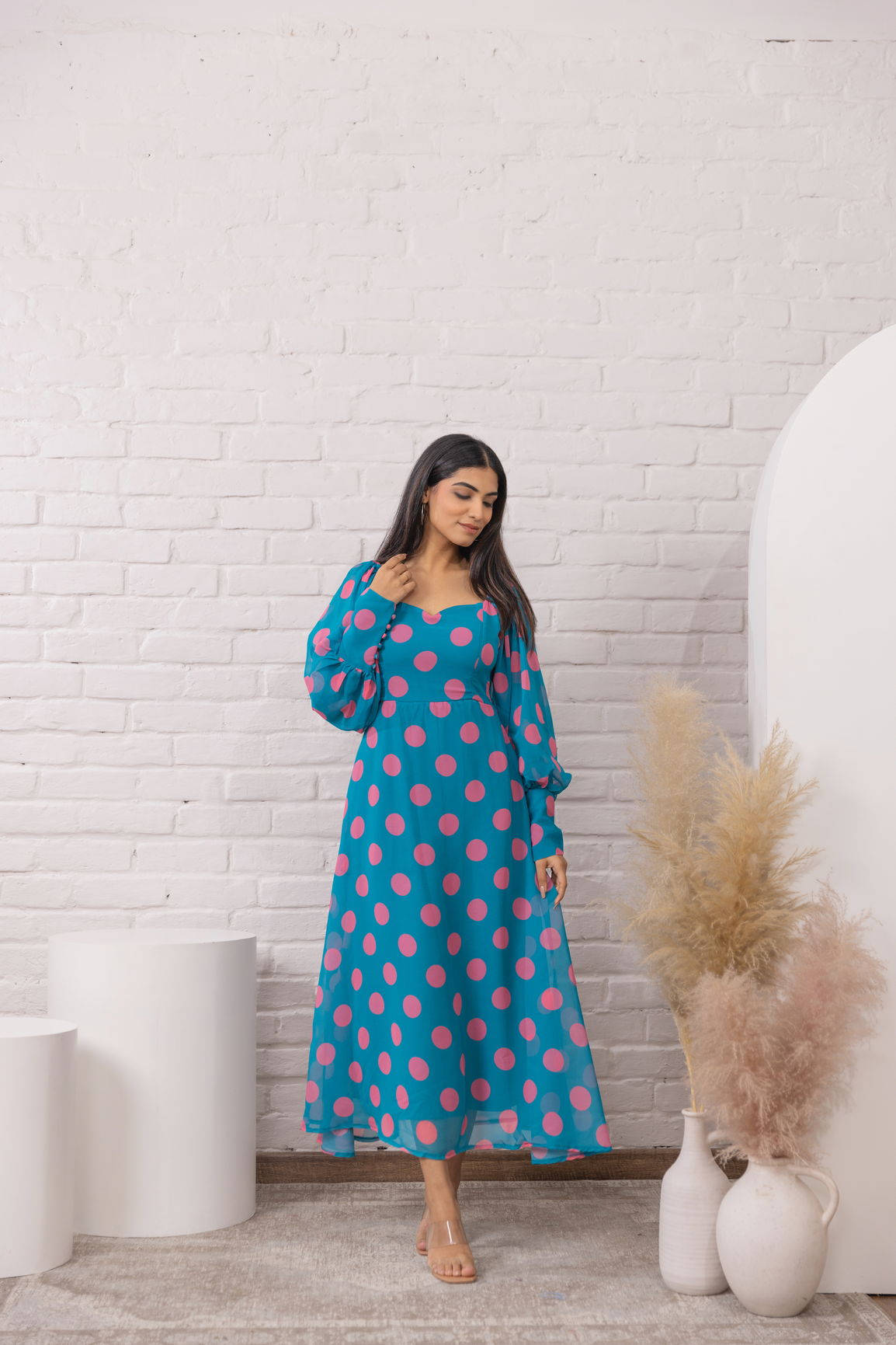 Blue polka dot maxi dress with long sleeves and flattering silhouette.