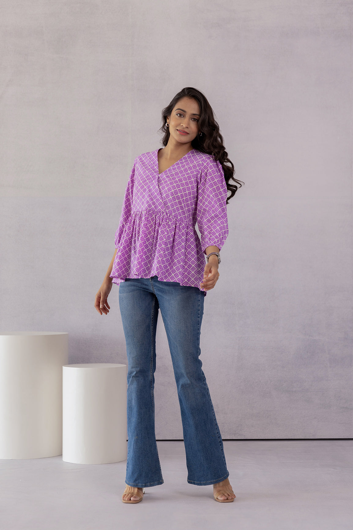 Lilac cotton top styled with flared jeans for a trendy look.