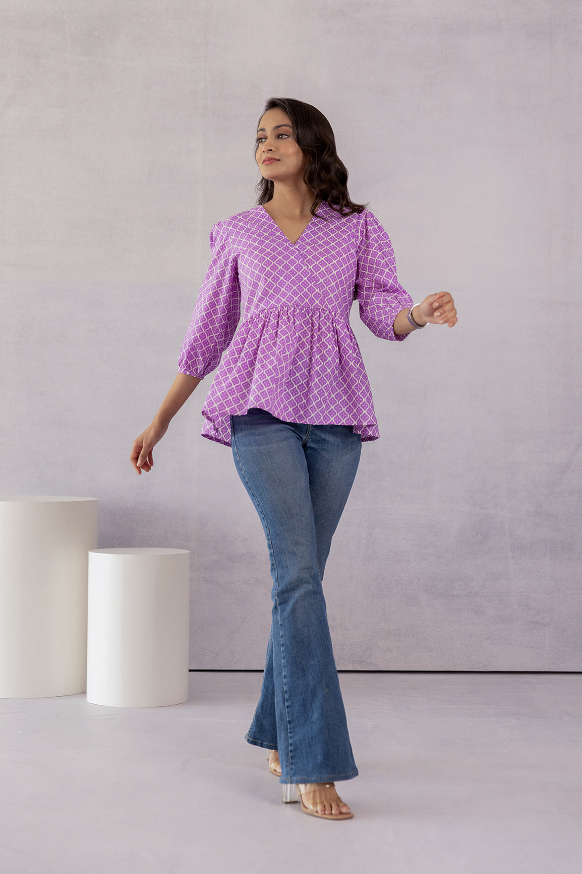 Lilac cotton top with peplum style, paired with flared jeans.