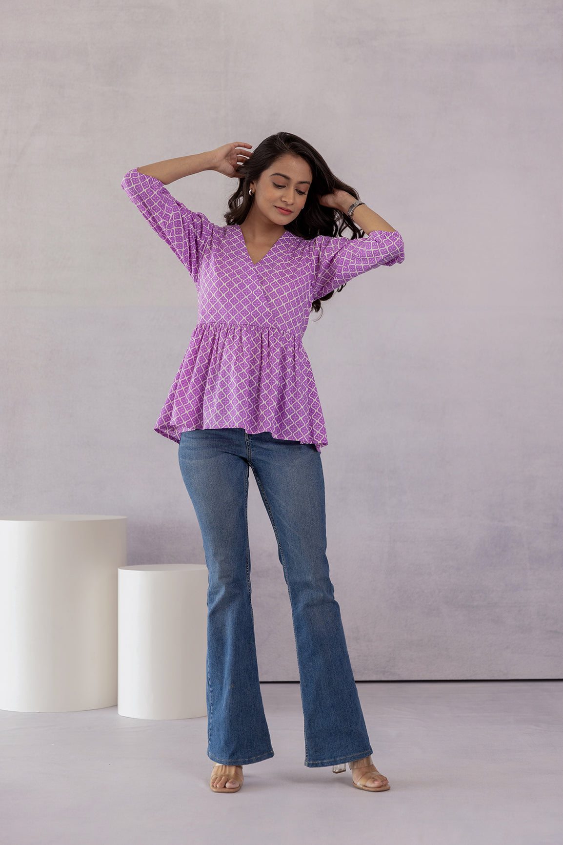 Stylish lilac cotton top paired with flared jeans.