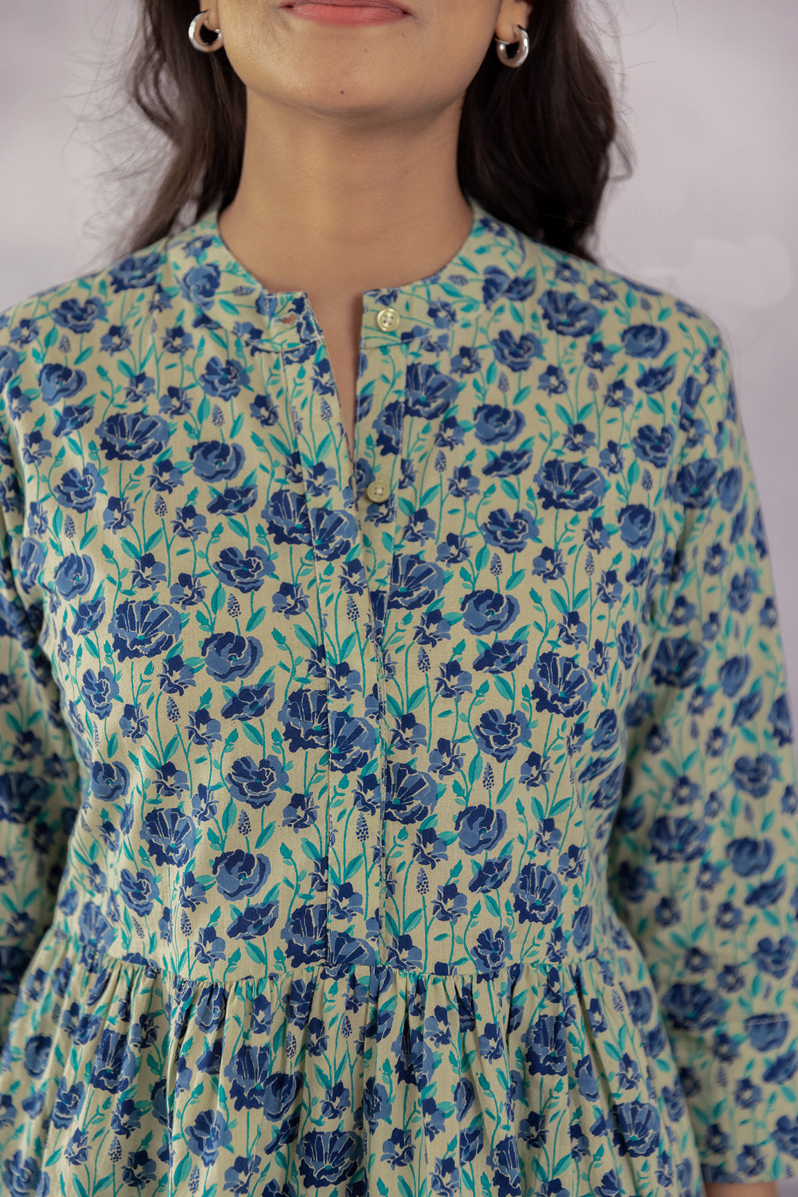 Green cotton top with blue floral print, perfect for summer style.
