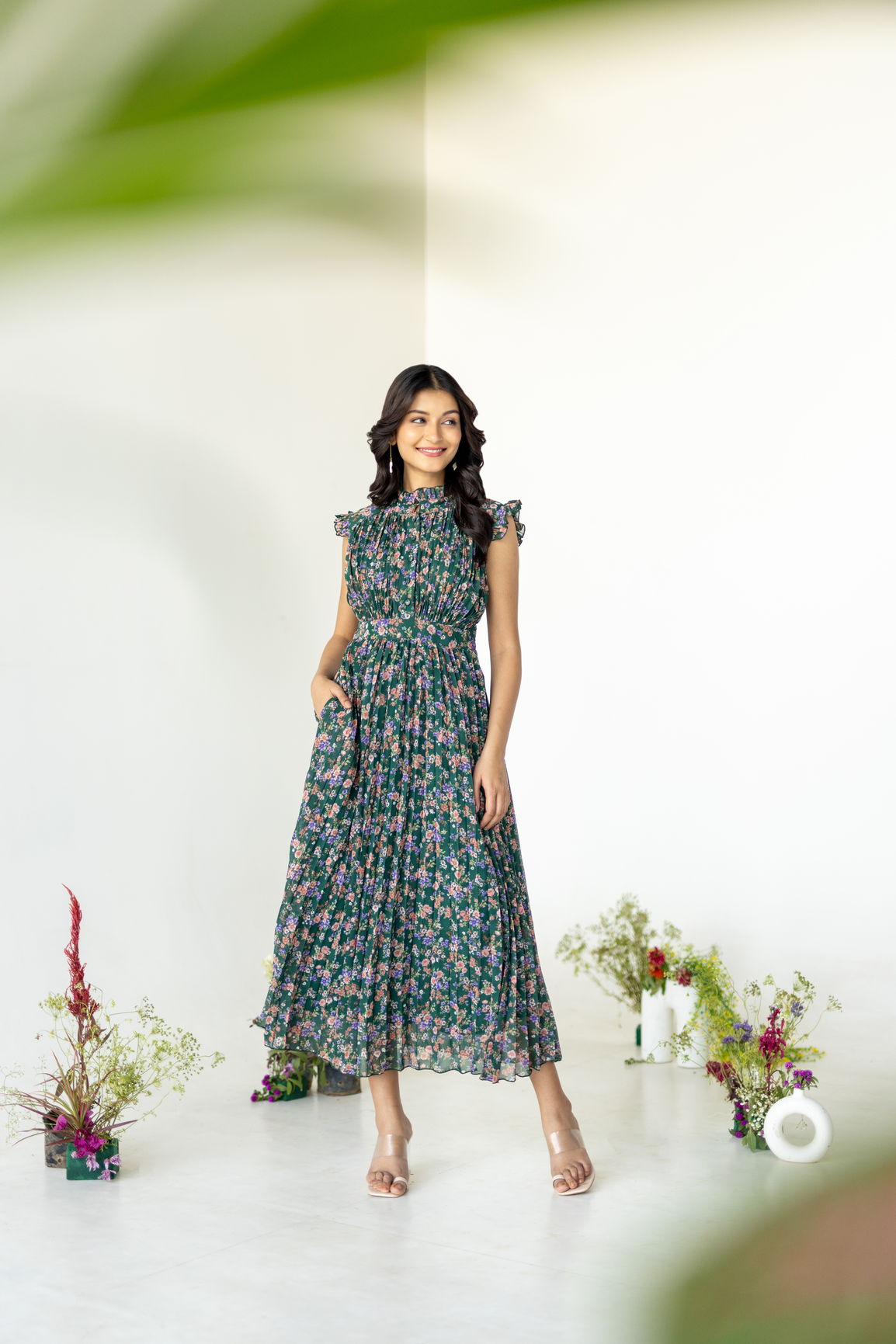 Emerald pleated maxi dress with floral patterns and pockets.