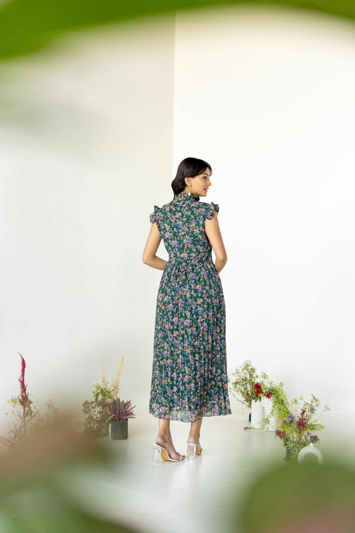 Emerald pleated maxi dress with floral design, back view.