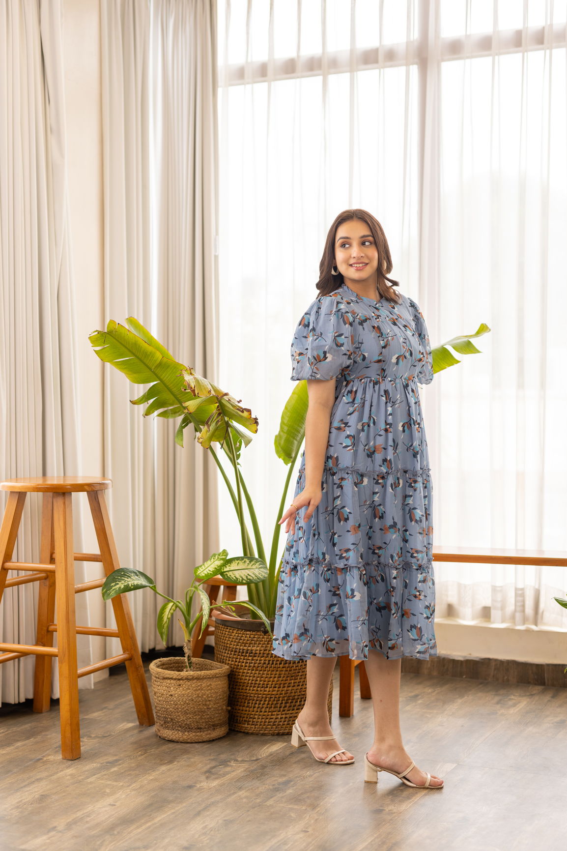 Floral nursing maxi dress worn indoors with plants in background.