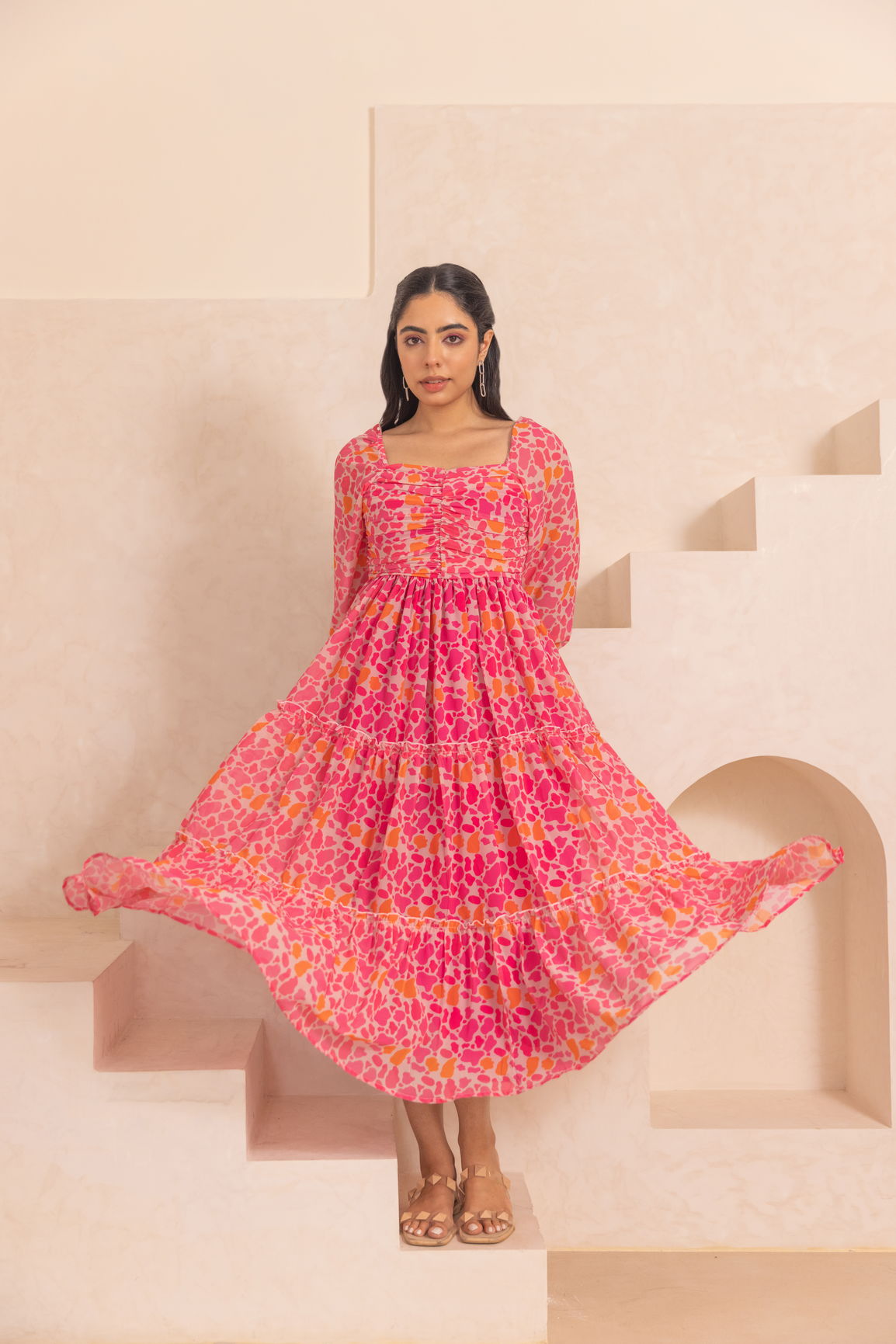 Bright pink mosaic print maxi dress in a stylish setting.