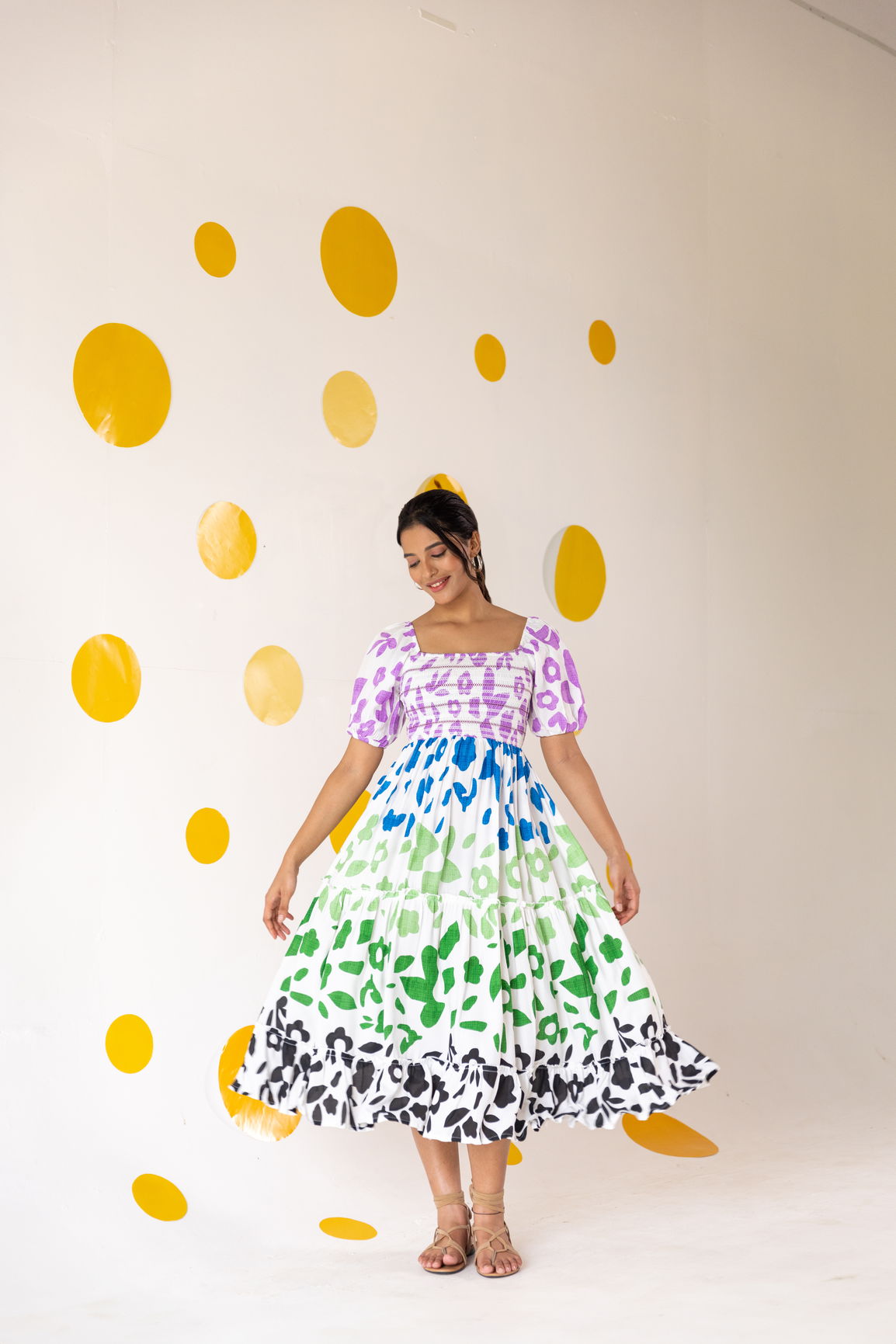 Colorful smocked maxi dress against vibrant polka dot background.