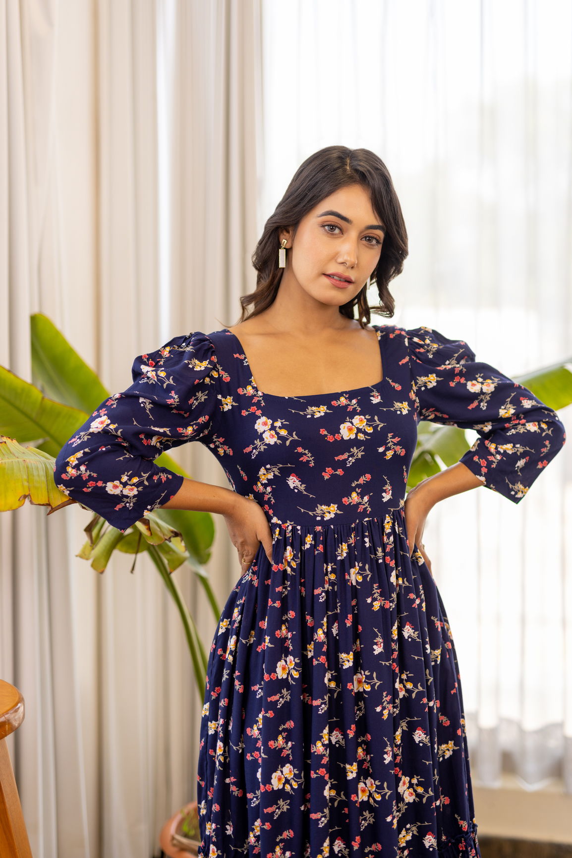 Navy blue floral maxi dress worn by a model indoors.