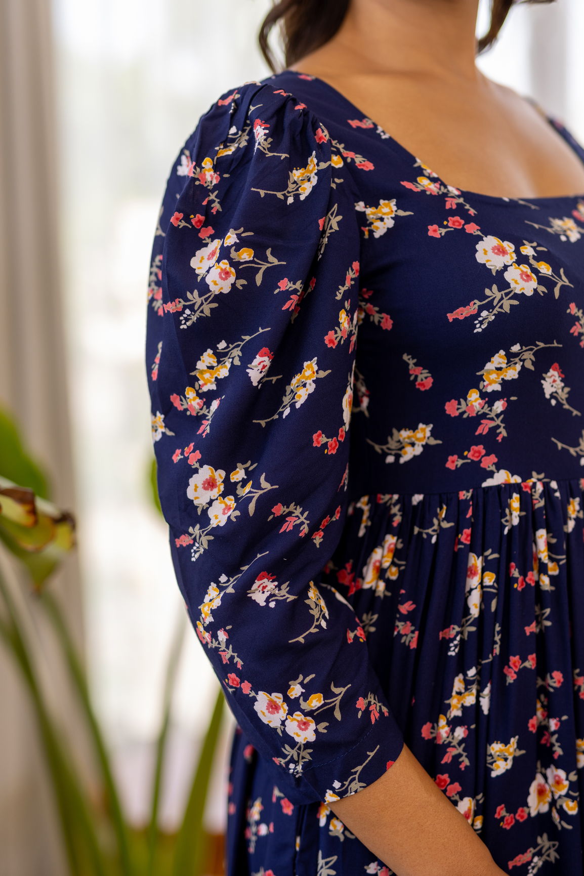 Navy blue floral maxi dress with puff sleeves and vibrant flowers.