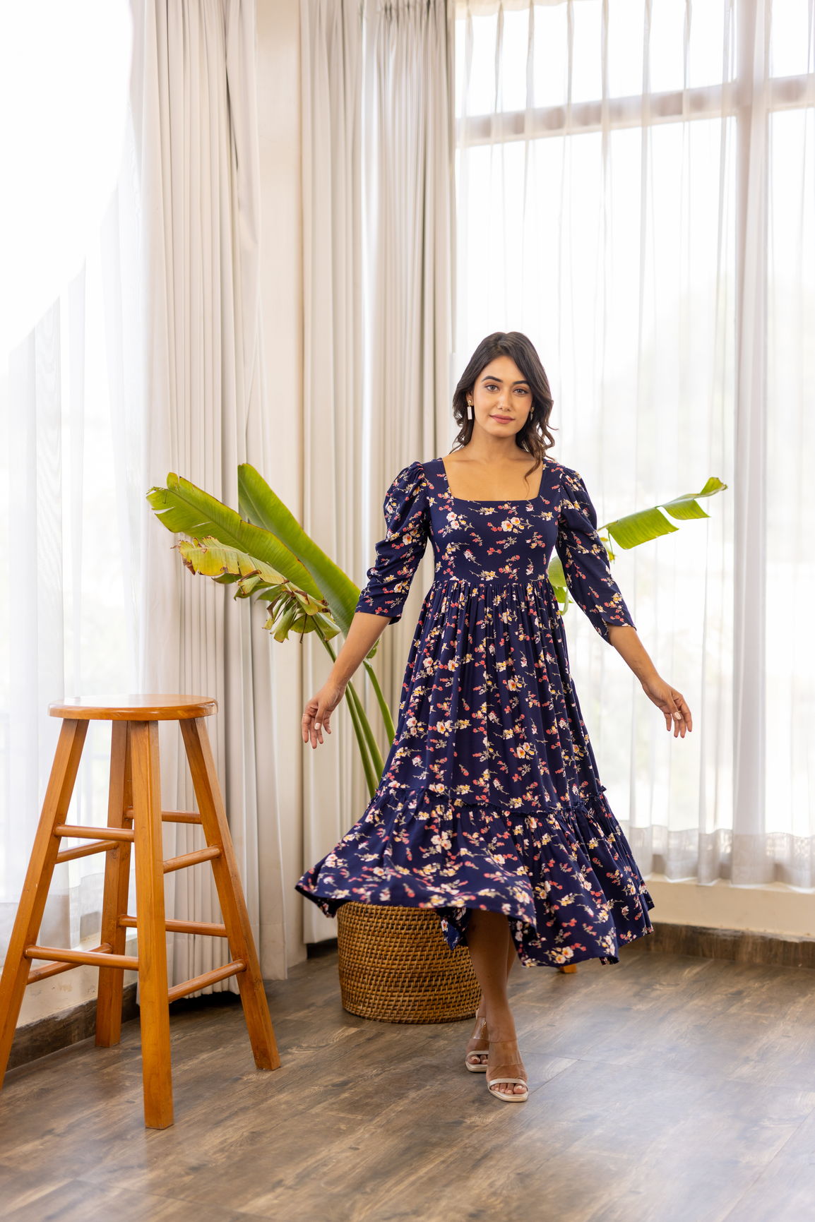 Navy blue floral maxi dress in a bright indoor setting.