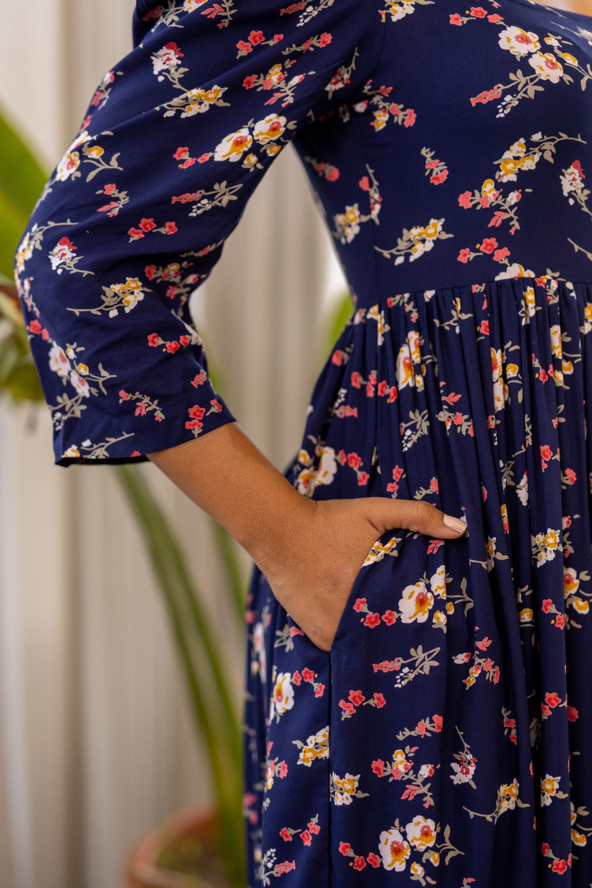Navy blue floral maxi dress featuring elegant pockets and vibrant flowers.