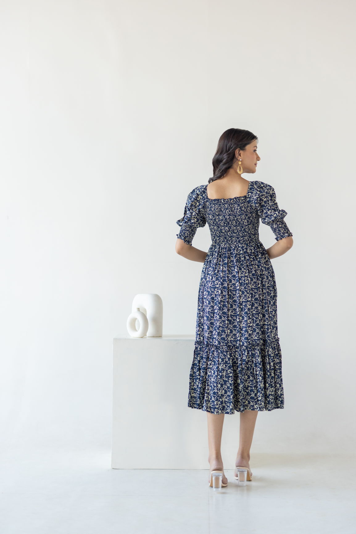 Woman wearing navy mosaic cotton maxi dress, showcasing back and style.