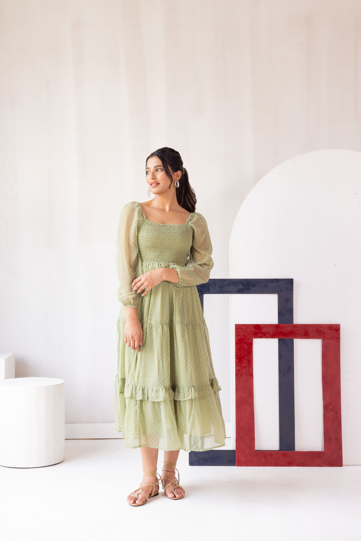 Pastel green smocked maxi dress on model in stylish setting.