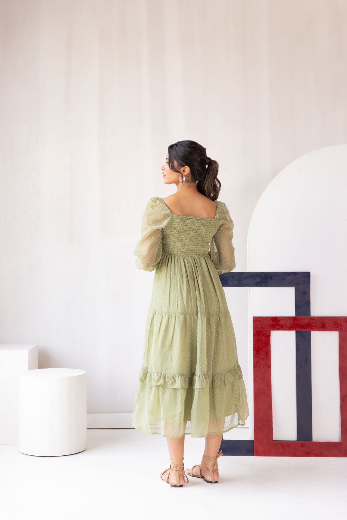 Pastel green smocked maxi dress with puff sleeves and tiered skirt.