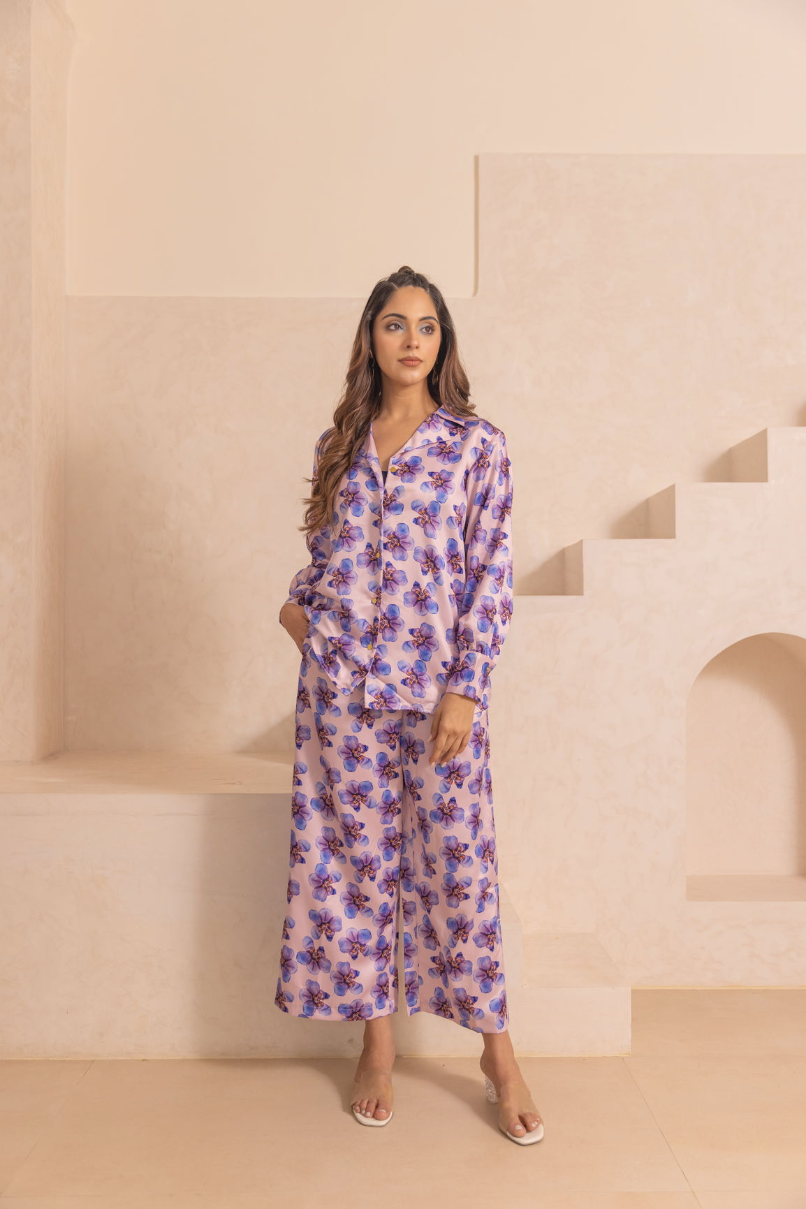 Model wearing pastel satin co-ord with floral design in soft colors.