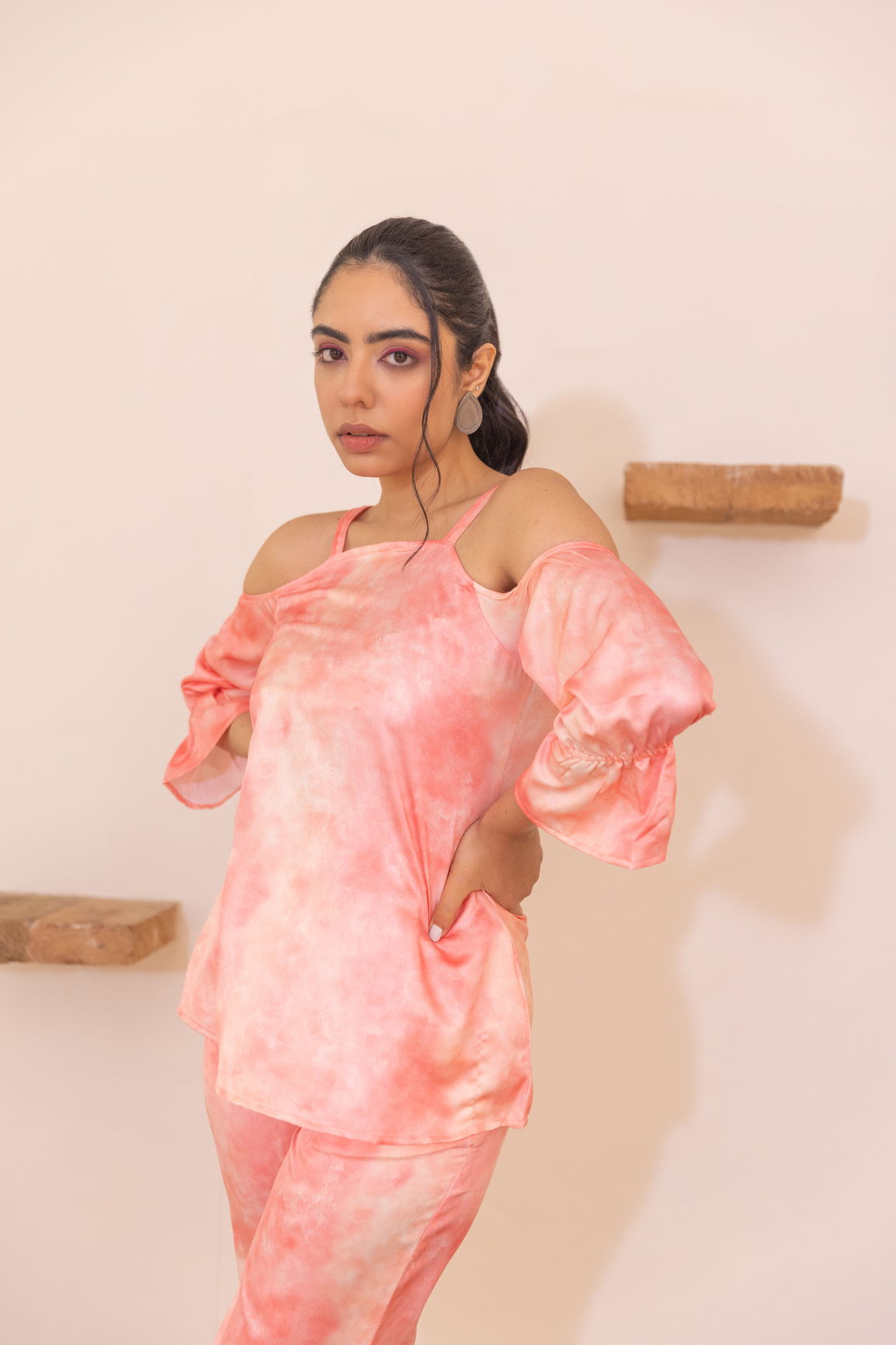 Peach off-shoulder co-ord set styled with soft, flowing fabric.