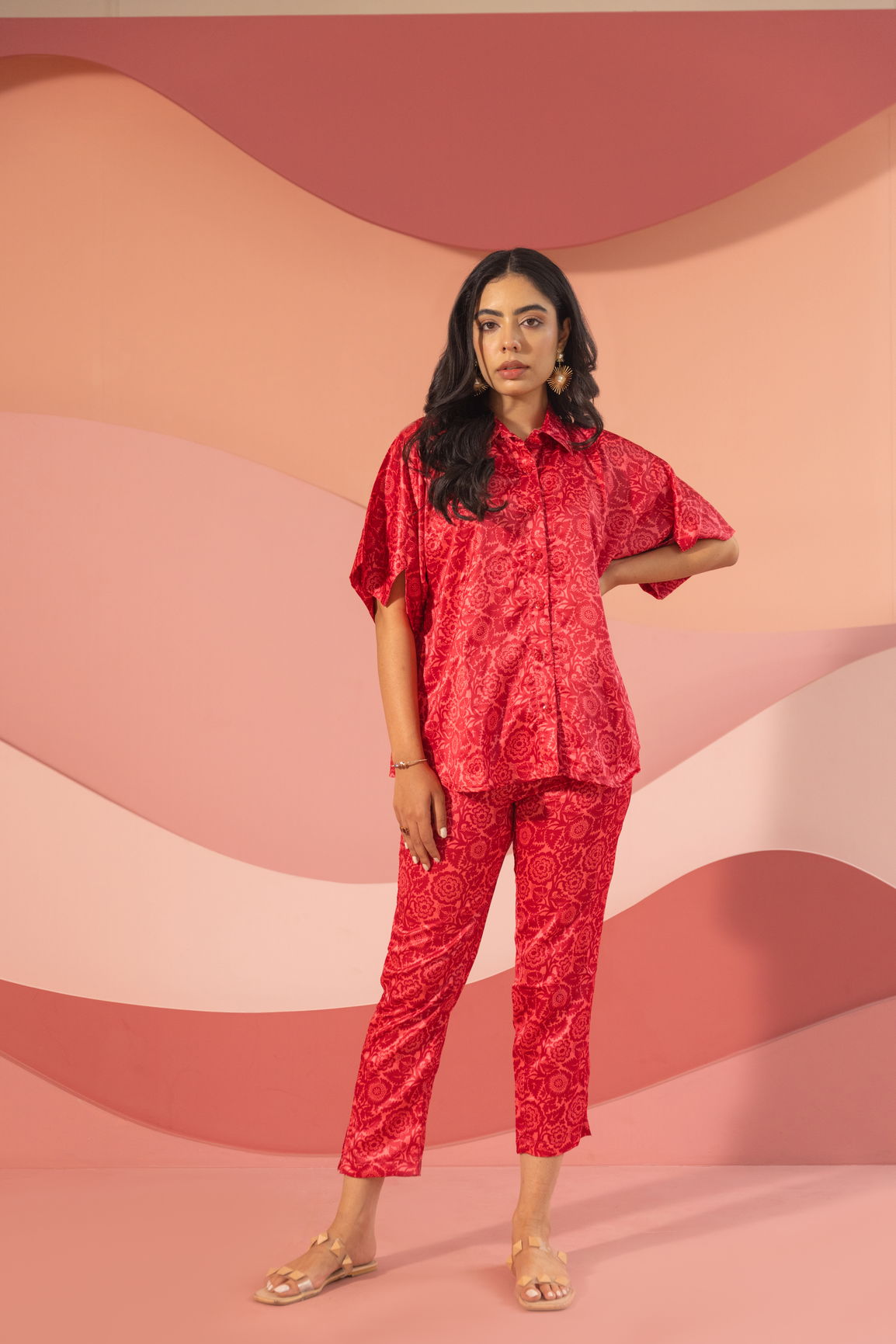 Pink satin co-ord set on model against abstract background.