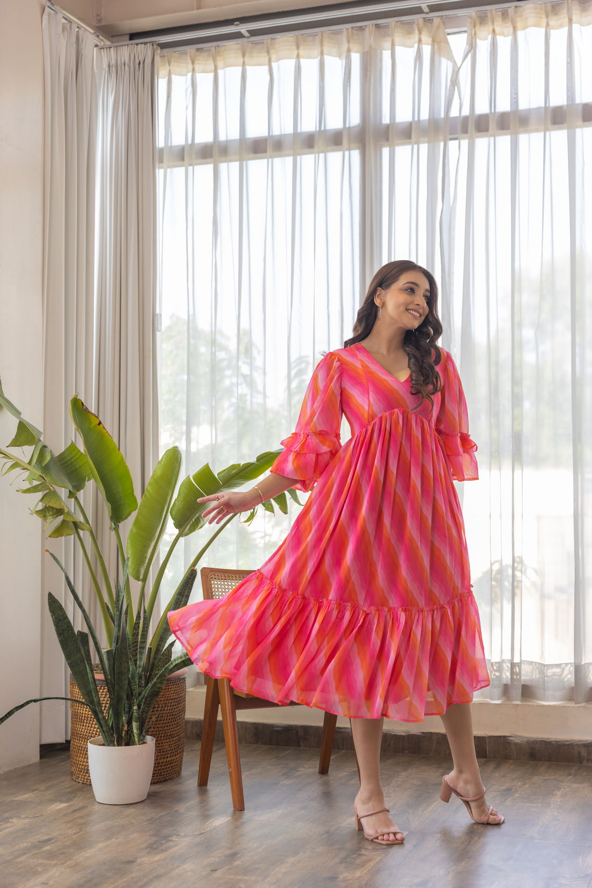Model in vibrant Pink Wave Nursing Maxi dress indoors.