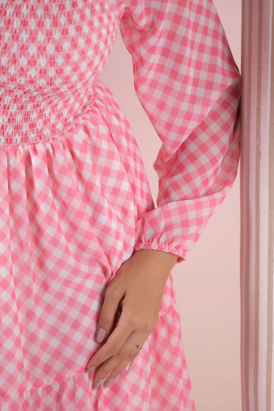 Pink gingham maxi dress with smocked bodice and long sleeves.