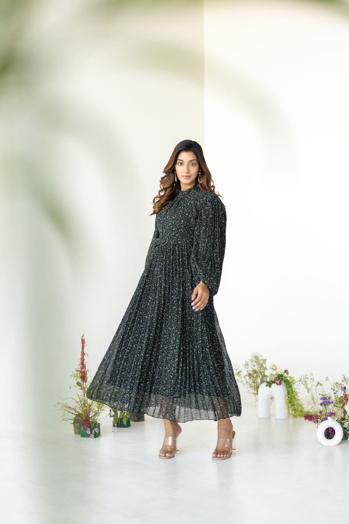Elegant model wearing PLEATS ON PLEATS MAXI dress in floral design.
