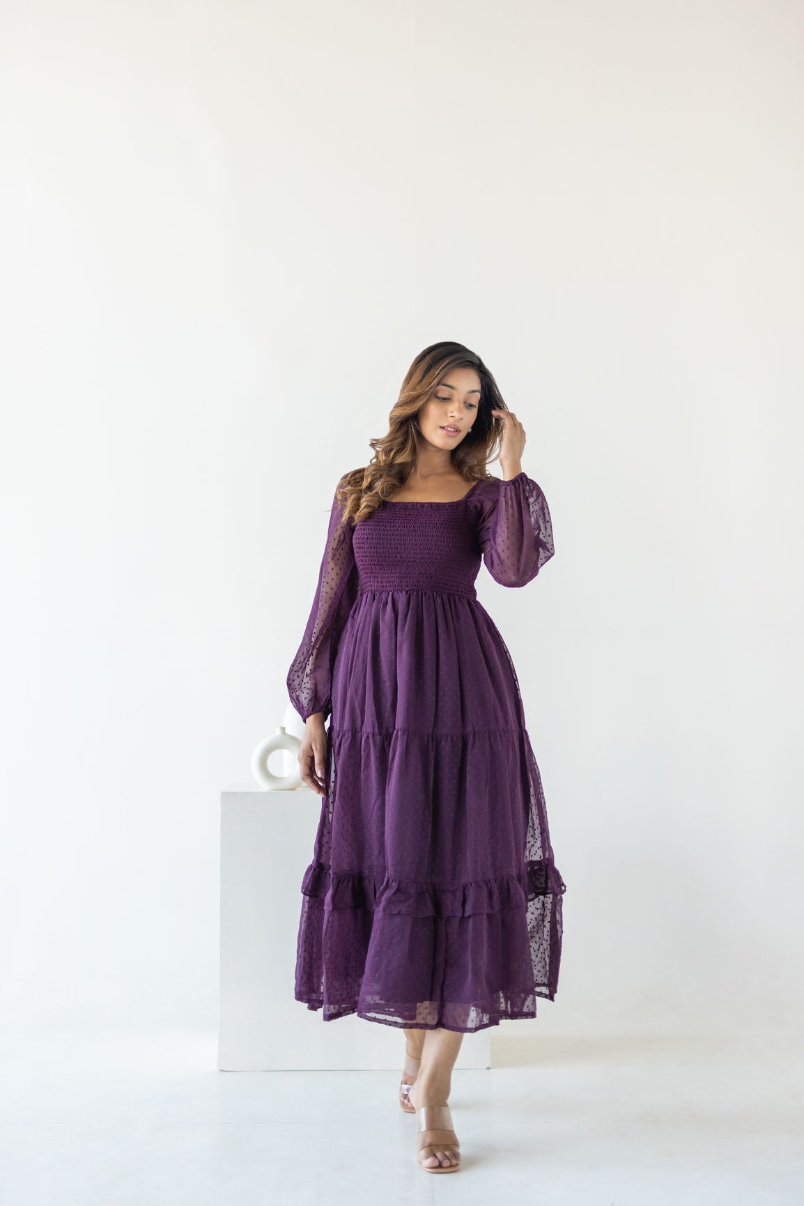 Plum smocked maxi dress with long sheer sleeves, perfect for any occasion.