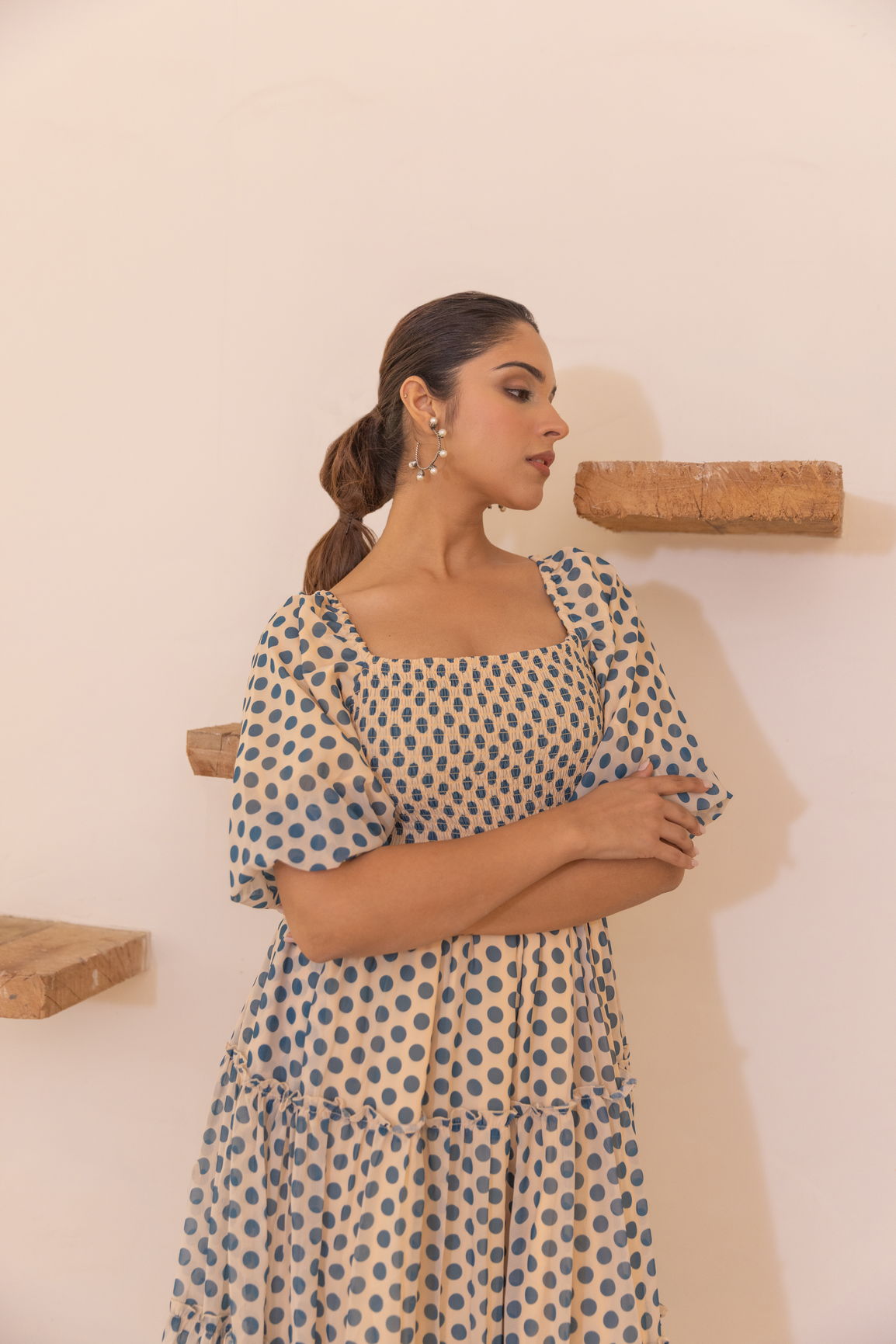 Polka smocked maxi dress styled elegantly against a minimalist backdrop.