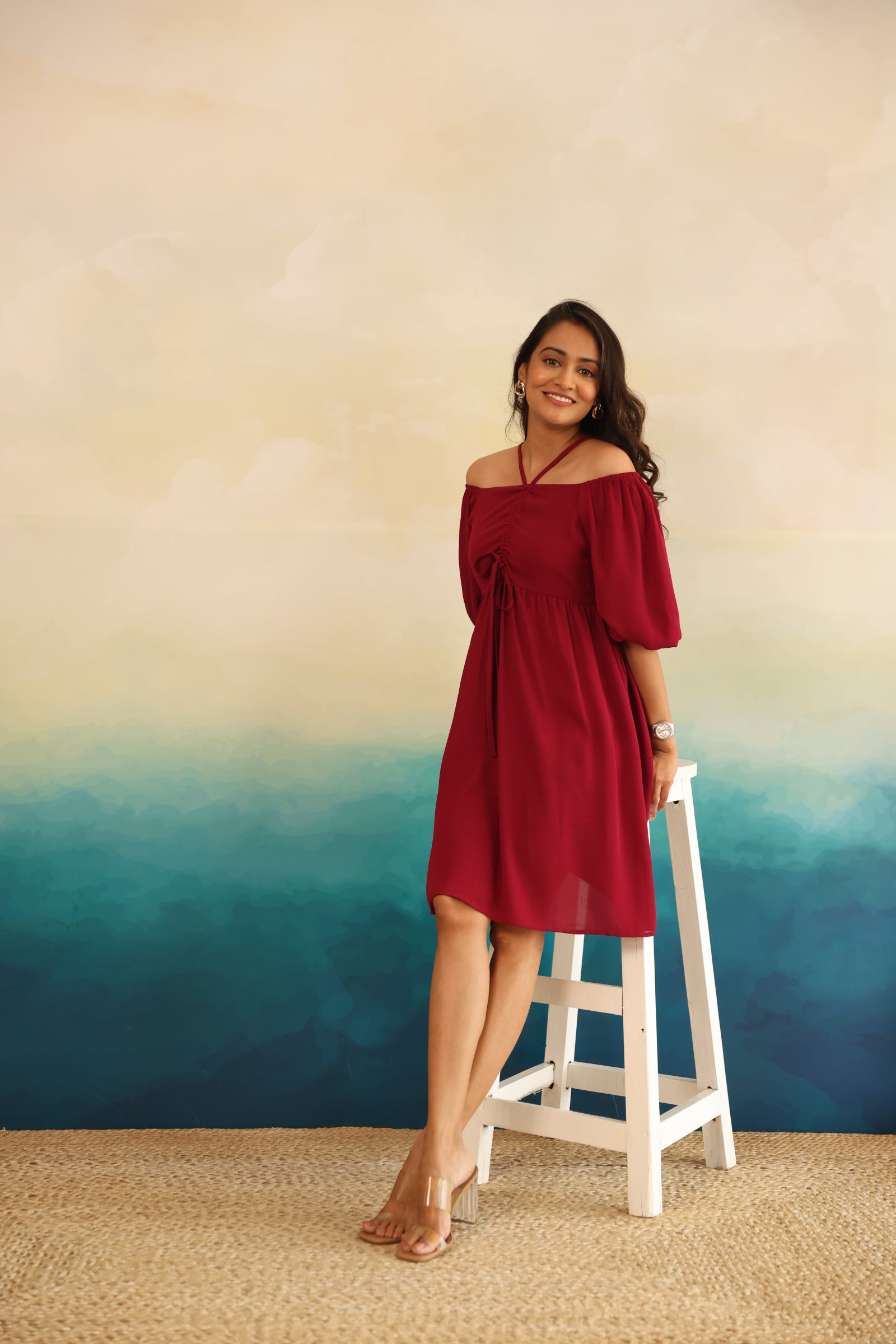 Burgundy midi dress on model against gradient background.