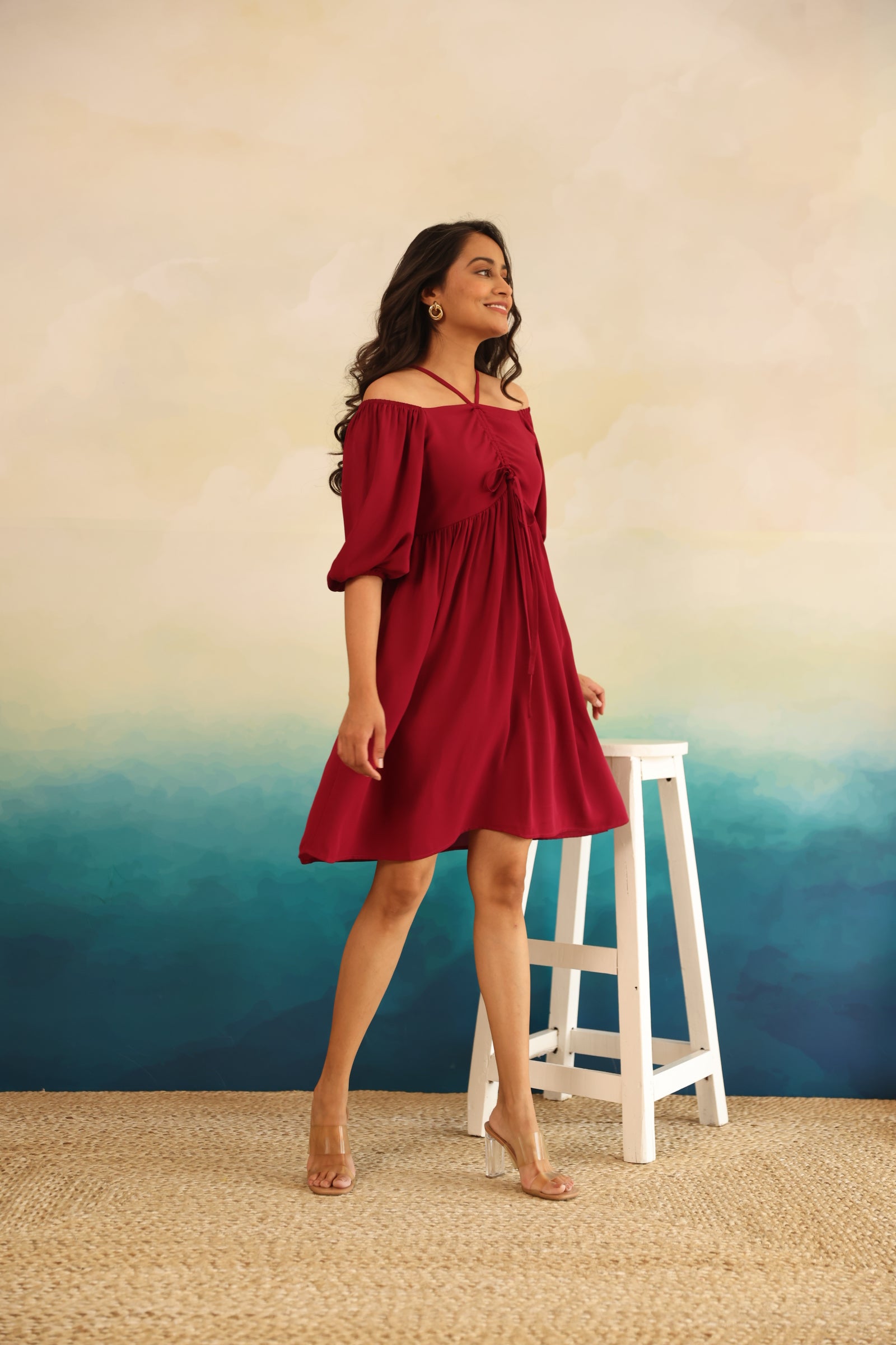 Burgundy midi dress on a model against a colorful backdrop.