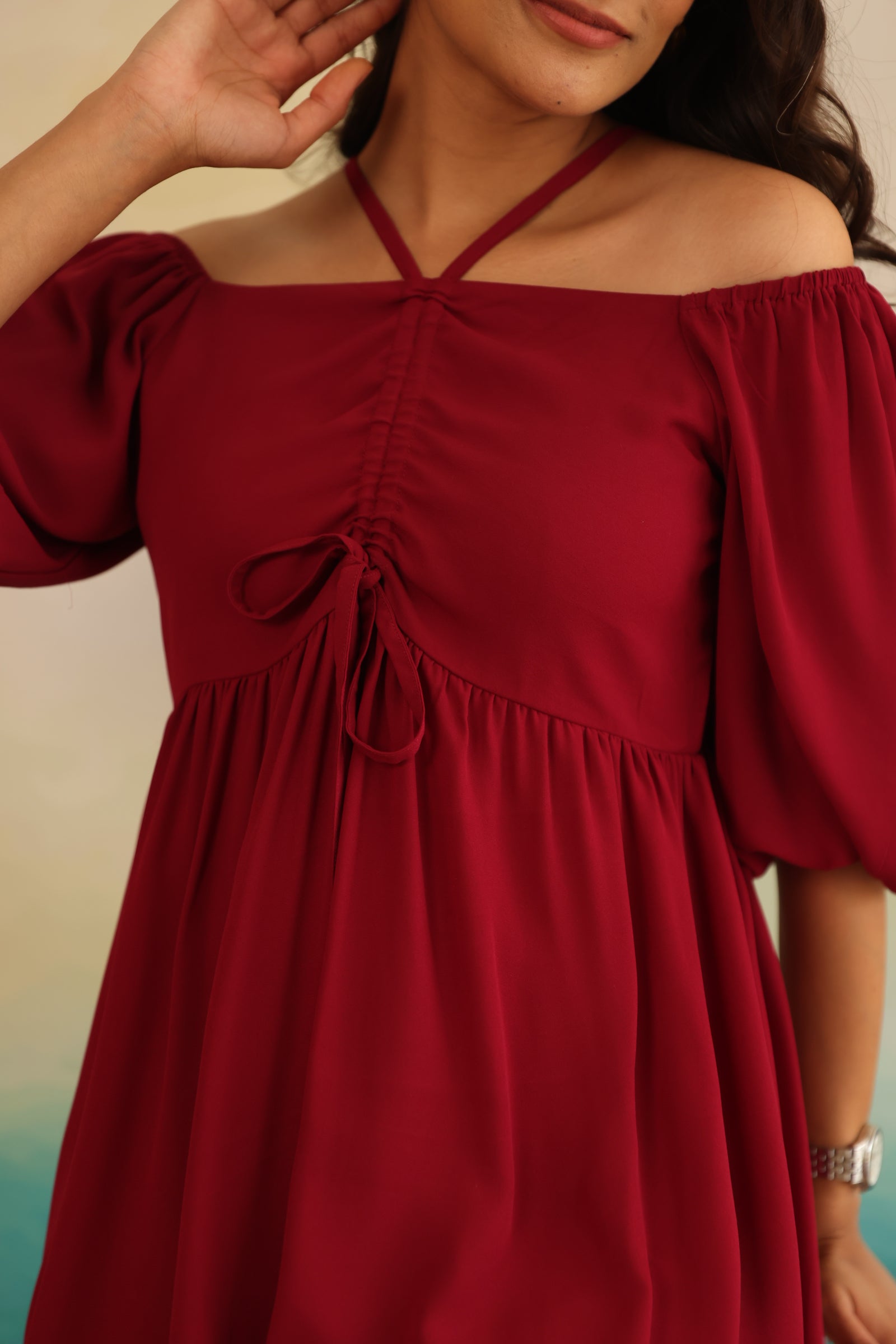 Burgundy midi dress with off-shoulder style and tie detail.