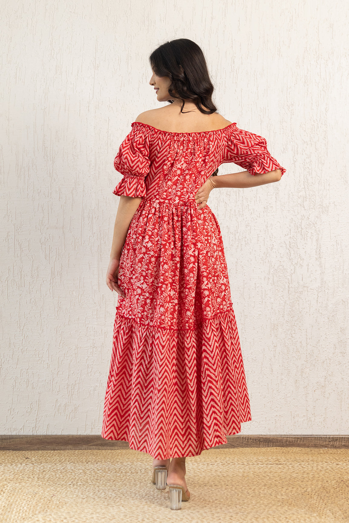 Woman wearing red off-shoulder cotton maxi dress with floral patterns.