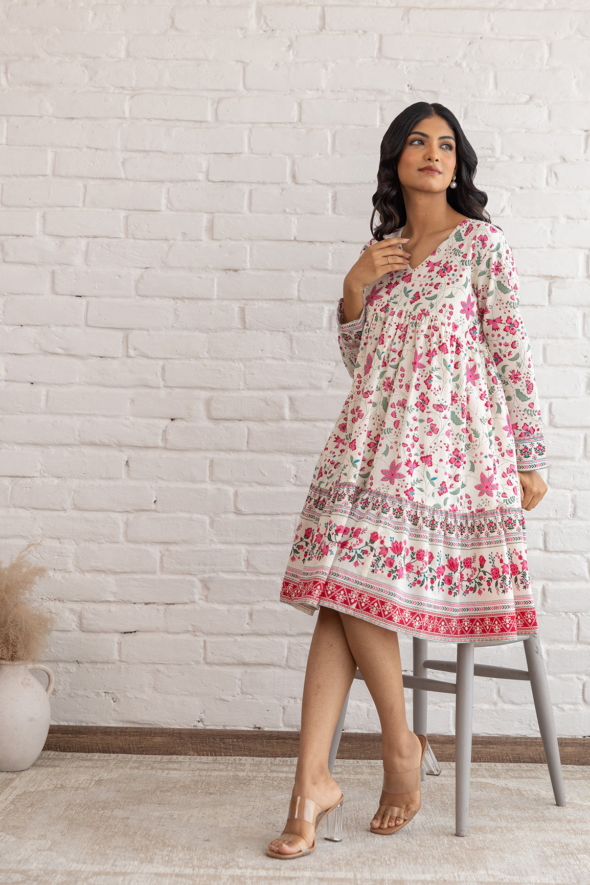 Floral cotton midi dress worn by model in bright setting.