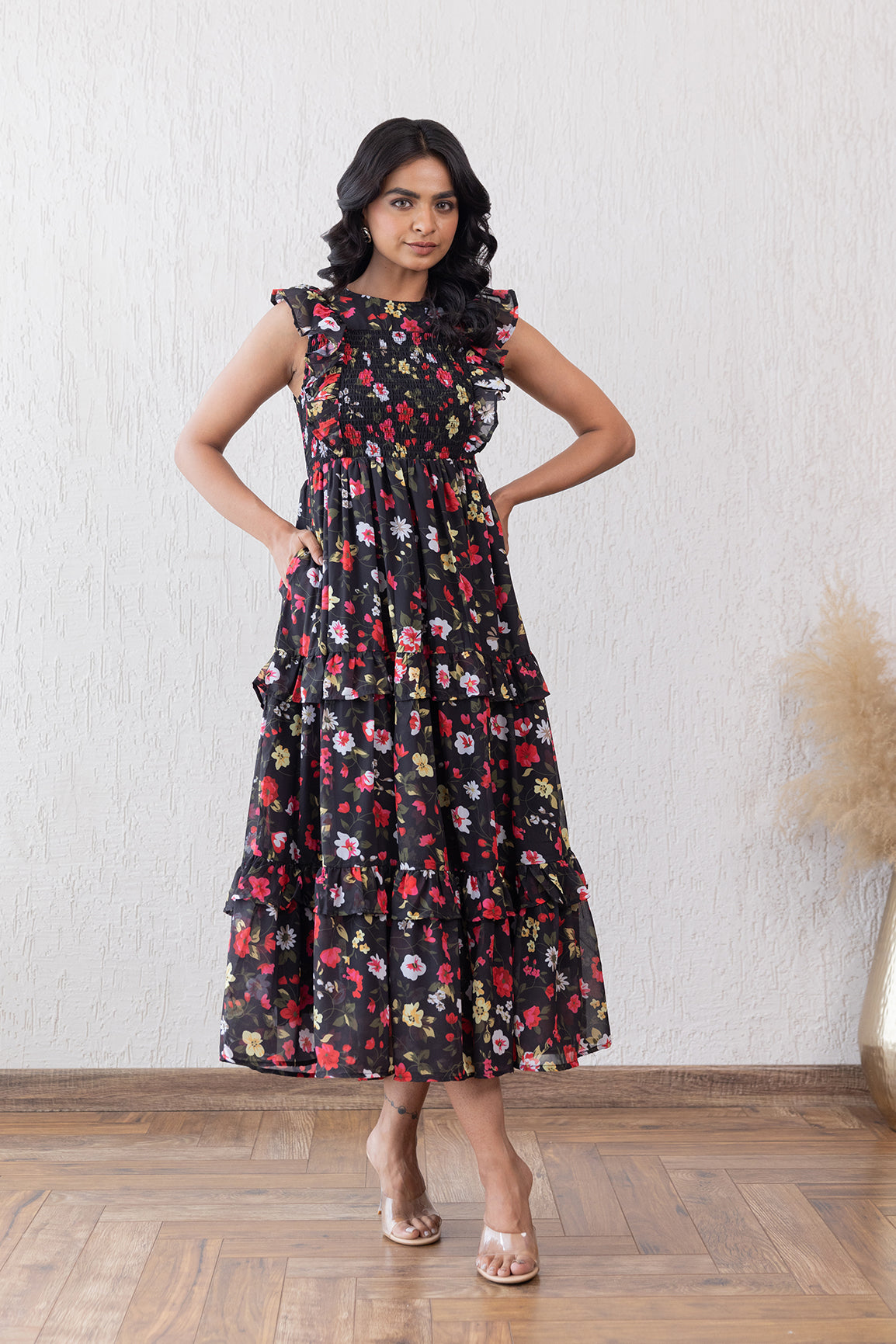 Black floral smocked maxi dress with ruffled sleeves and tiered design.