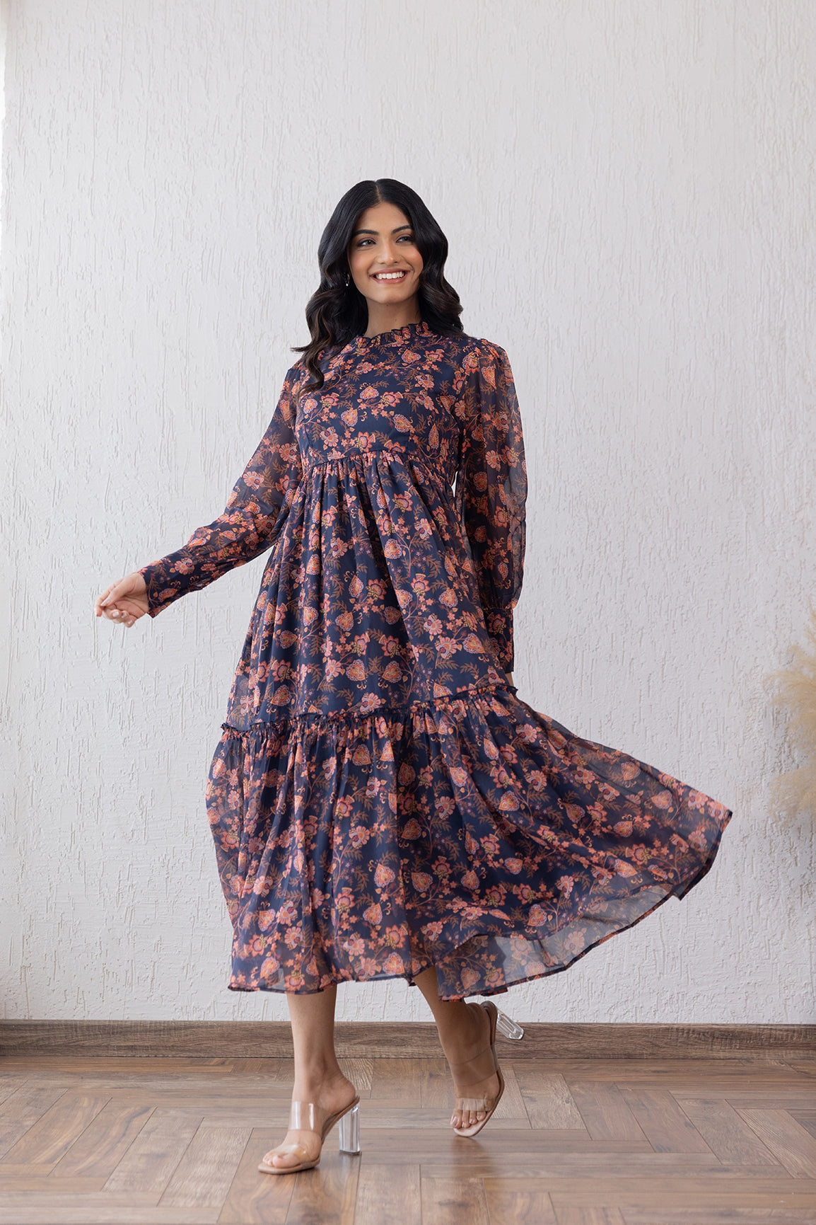 Elegant floral maxi dress with closed neck and flowing silhouette.