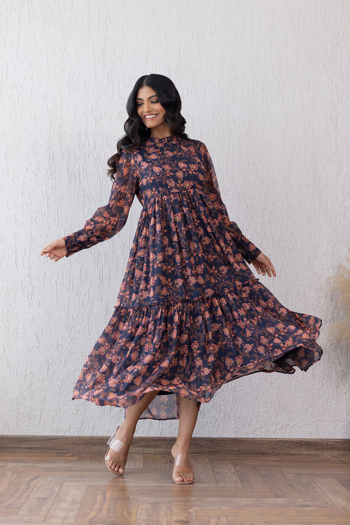 Stylish woman in floral Motif Closed Neck Maxi dress twirling gracefully.