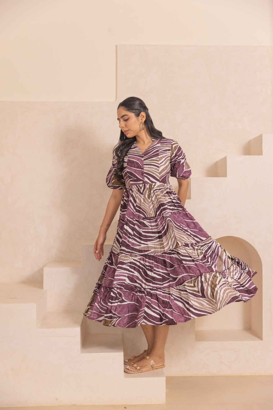 Elegant woman wearing WAVE MAXI dress with a stylish purple pattern.
