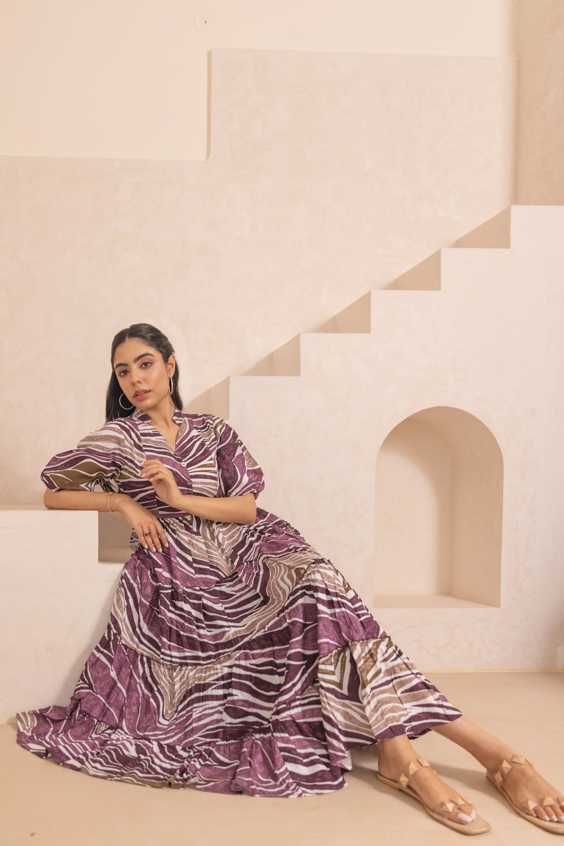 Stylish woman in purple WAVE MAXI dress against soft background.