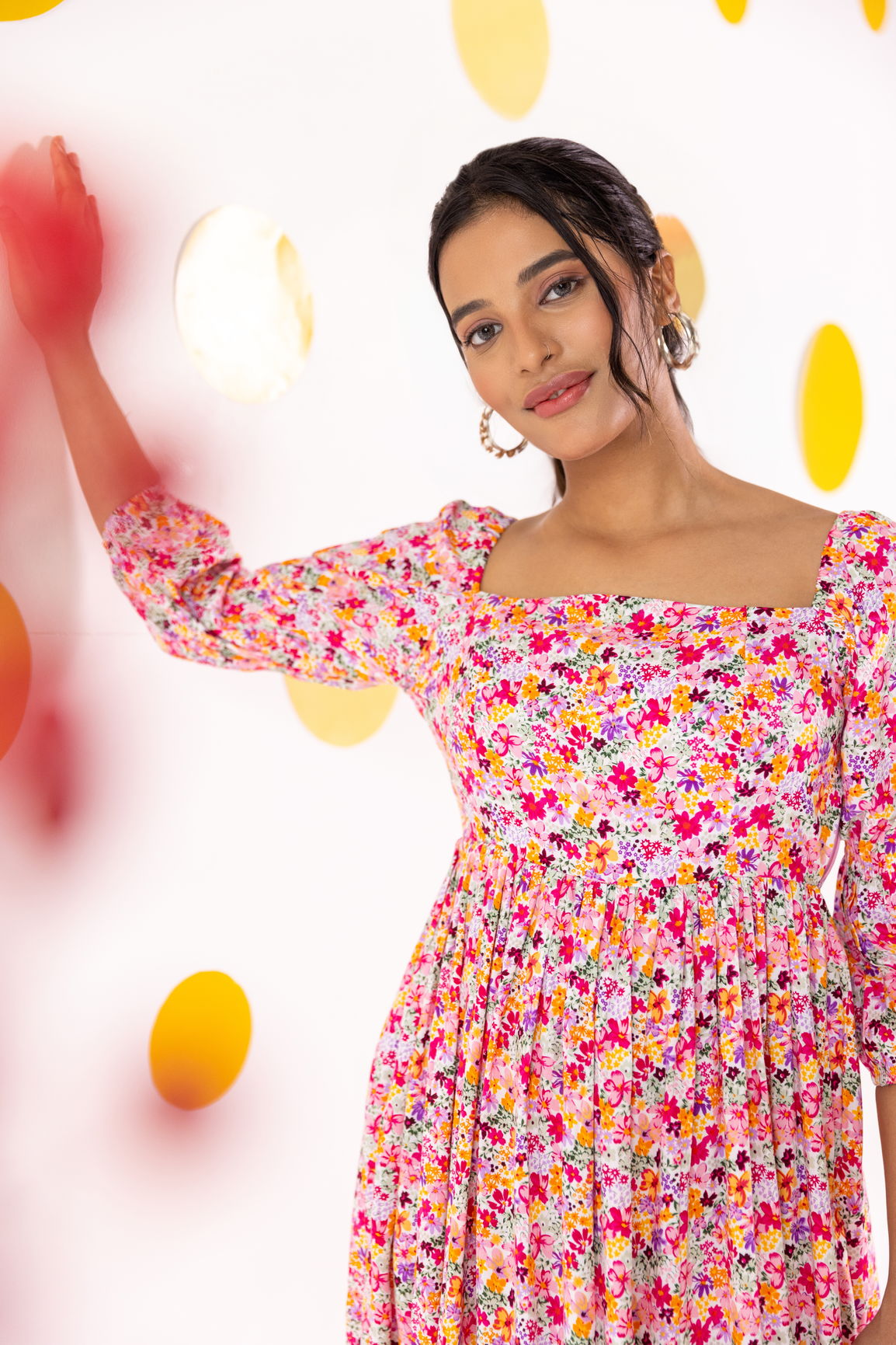 White floral cotton maxi dress on a model in a colorful backdrop.