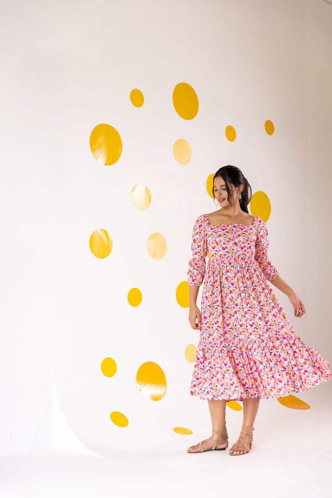 Model wearing a white floral cotton maxi dress against a colorful backdrop.