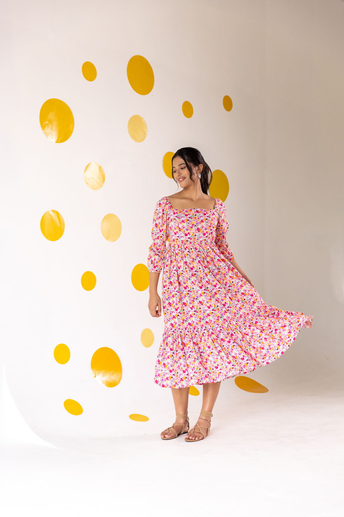 Woman in white floral cotton maxi dress with yellow polka dots background.