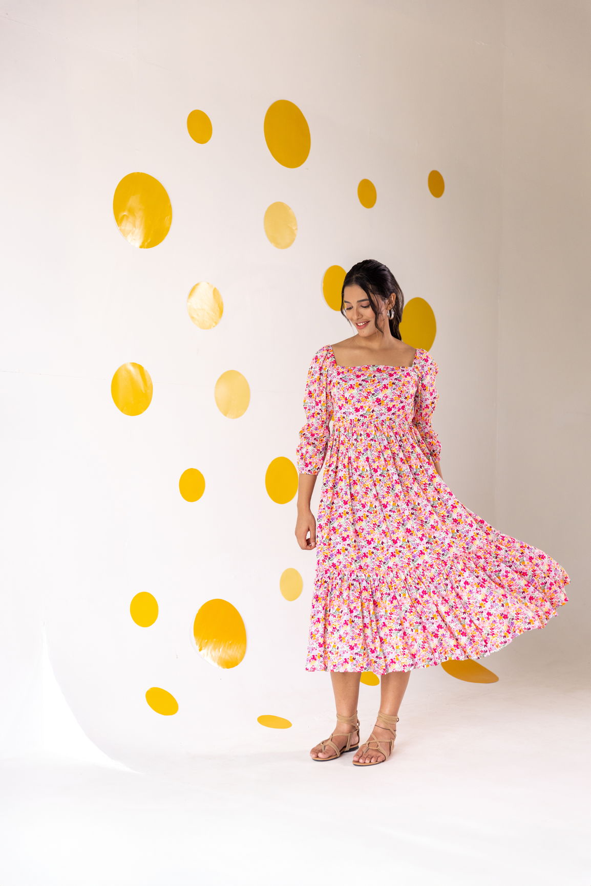 Model wearing a white floral cotton maxi dress against a yellow polka dot backdrop.