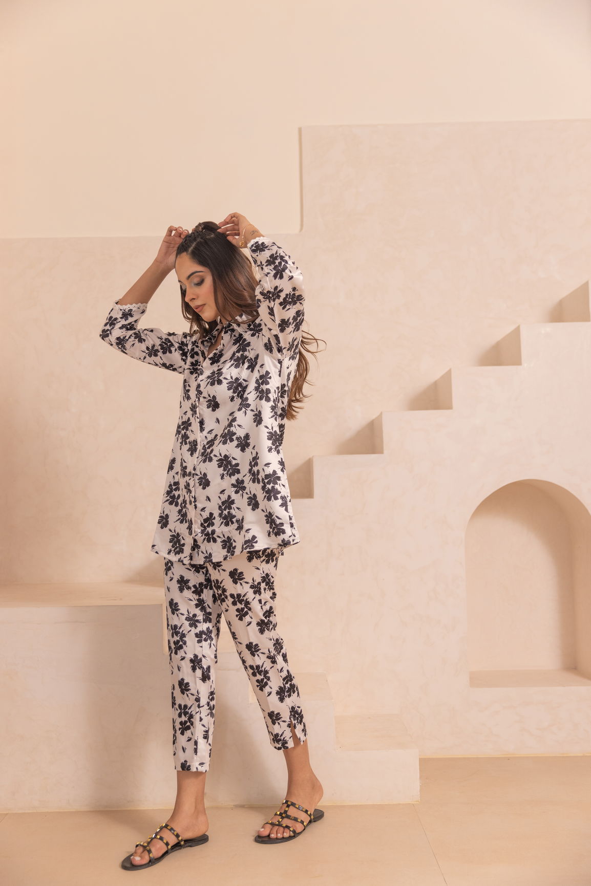 White floral satin co-ord set model posing in stylish interior.