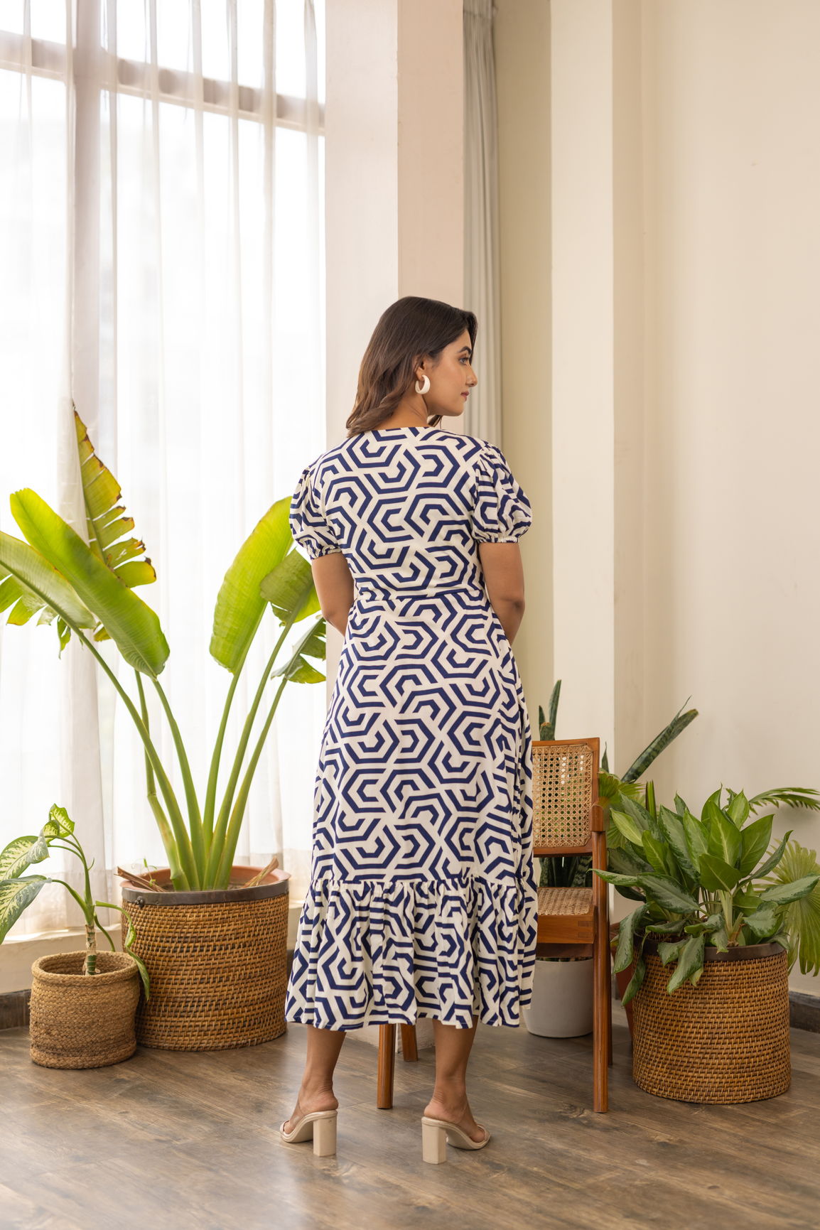 Elegant woman in patterned nursing maxi dress with ruffled hem.