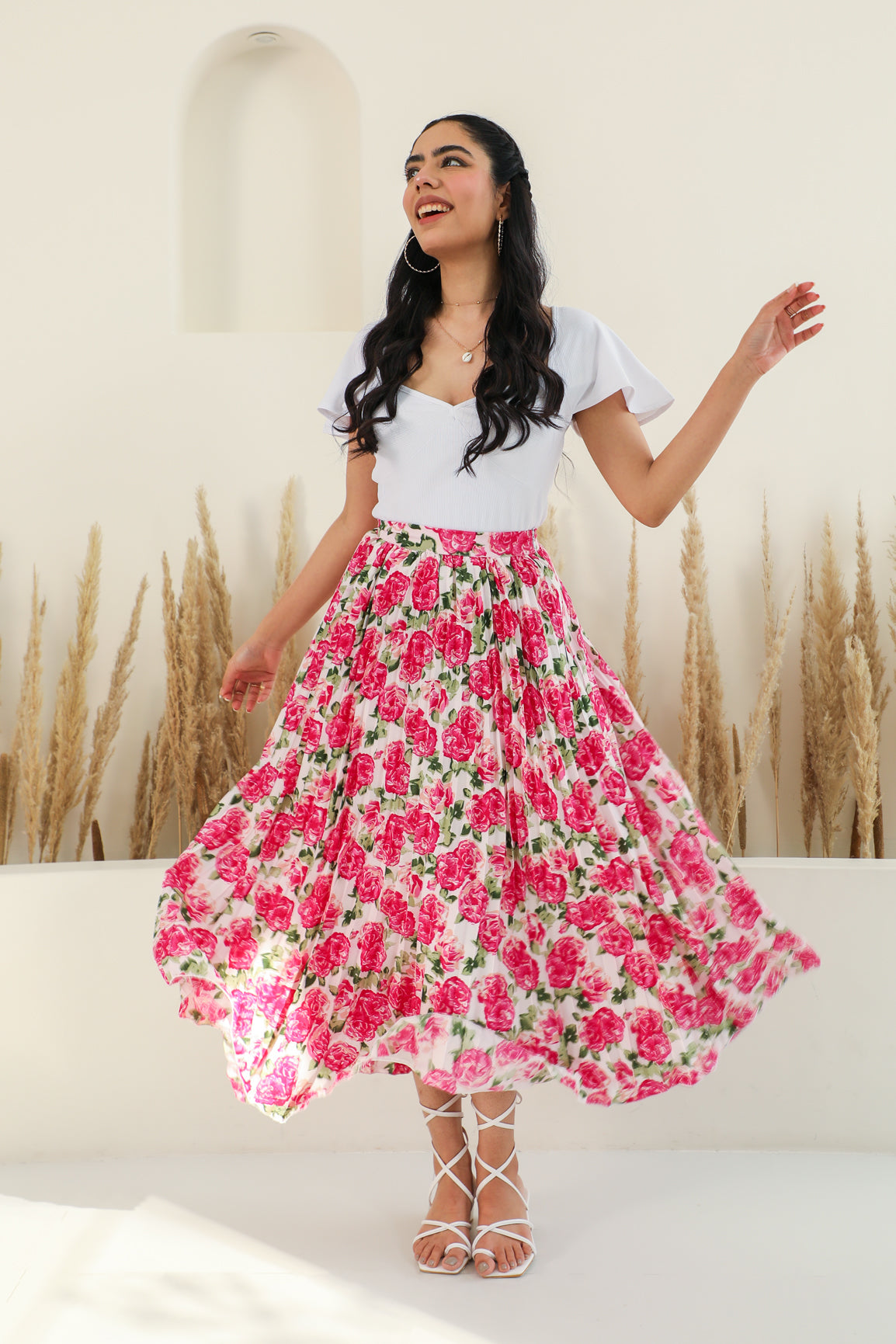 Floral pleated co-ord outfit featuring a smiling woman in a stylish, vibrant setting.