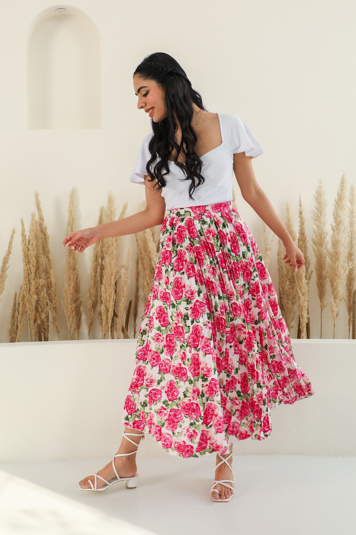 Floral pleated co-ord outfit with stylish model against neutral backdrop.