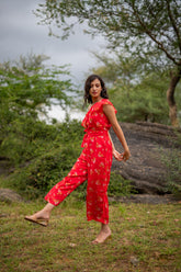 Floral one-shoulder jumpsuit in outdoor setting, stylish summer fashion.