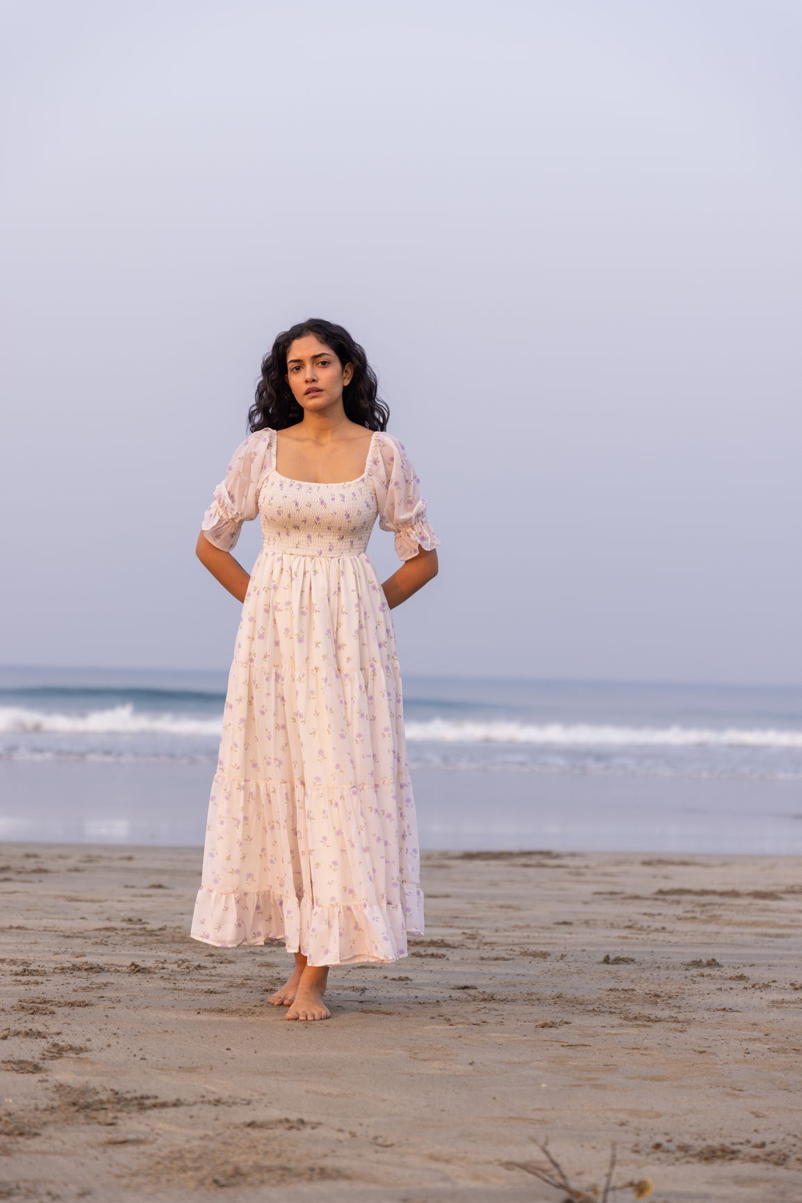 Elegant MINIMAL MAXI dress on beach during sunset, showcasing effortless style.